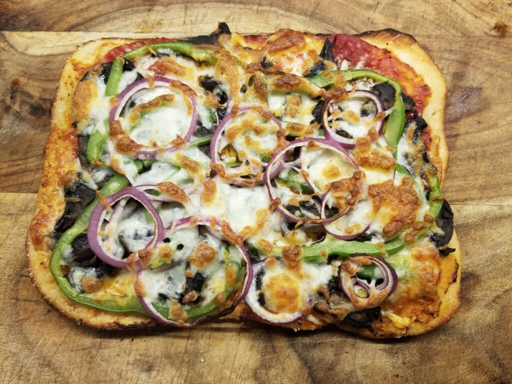 Sourdough Pizza Crust topped with mushrooms, peppers, and onions