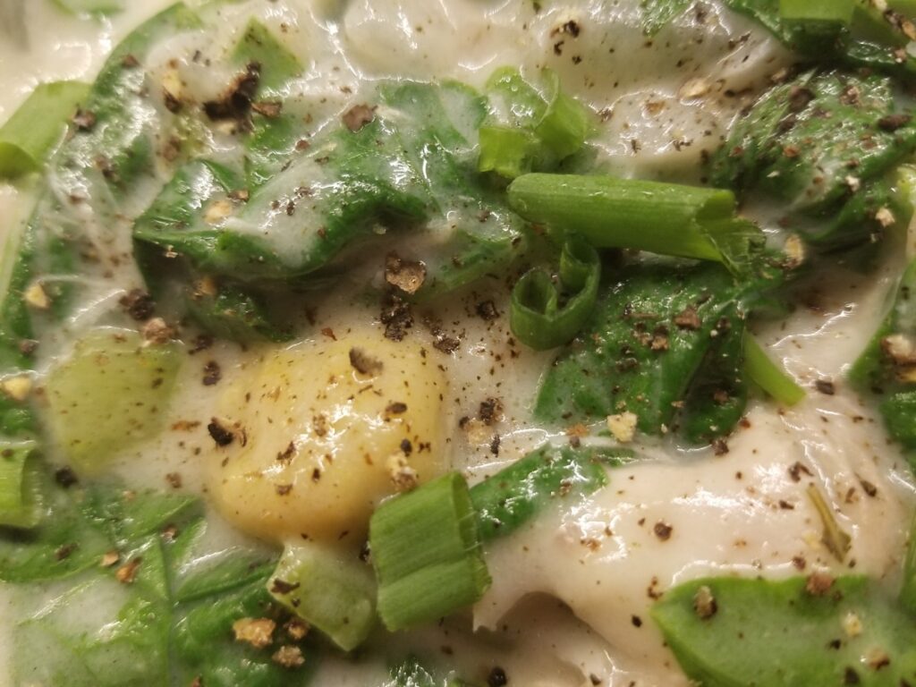 Close-up of creamy spinach and carrot gnocchi soup