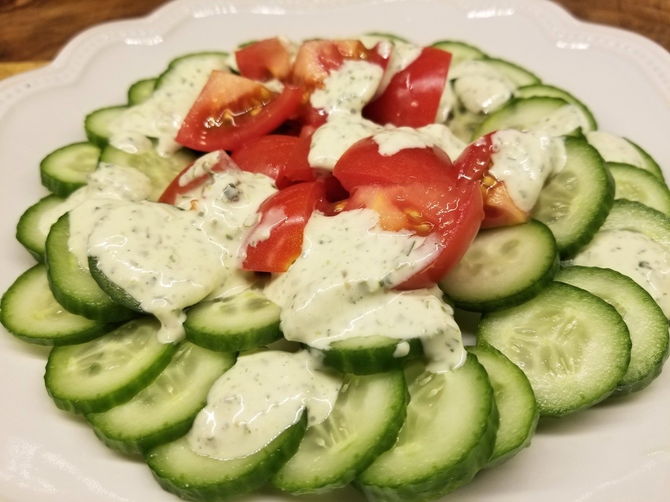 Green Goddess Dressing drizzled over cucumbers and tomatoes