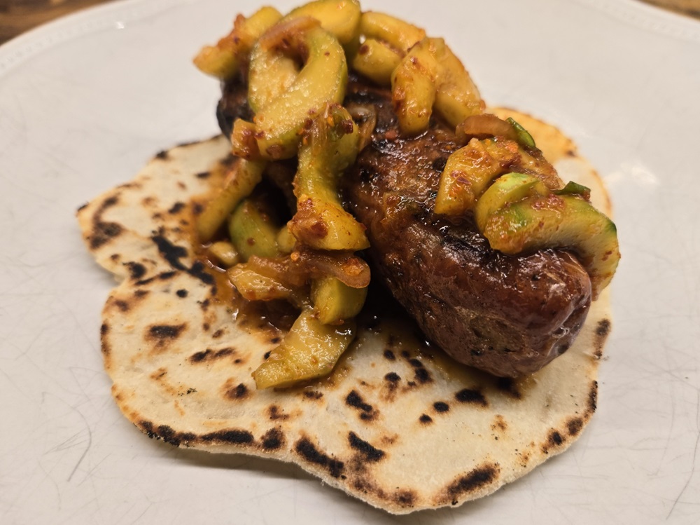 Chicken sausage smothered in Cucumber Kimchi