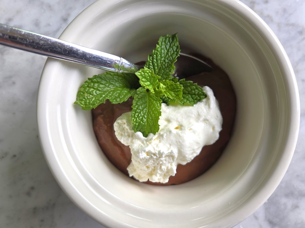 Warm Chocolate Pudding with whipped cream and mint